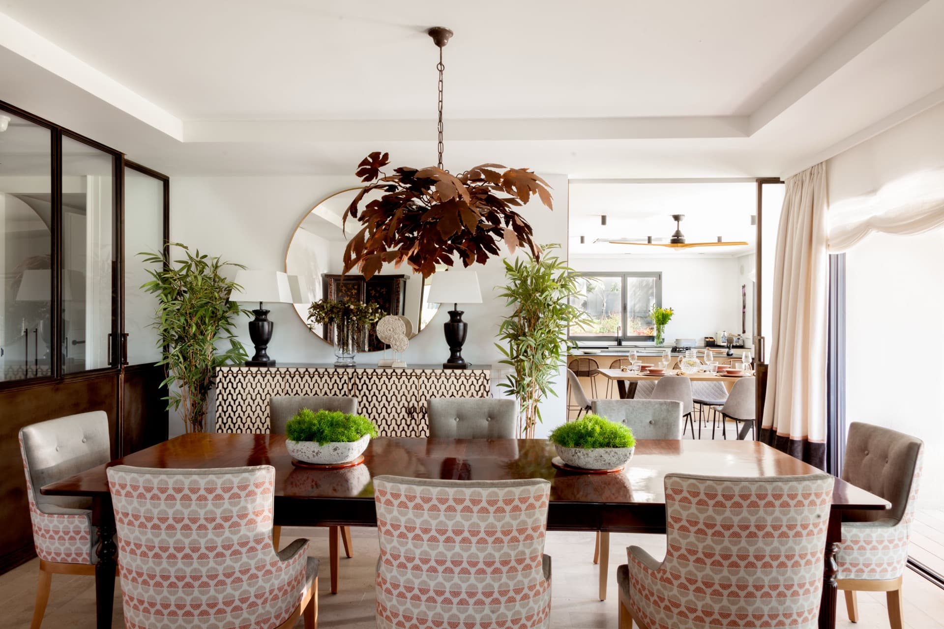 Comedor de Casa Brisa con mesa de madera, tejidos claros y luminaria escultórica